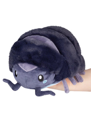 A plush that looks like a dark purple roly poly sitting on a hand.