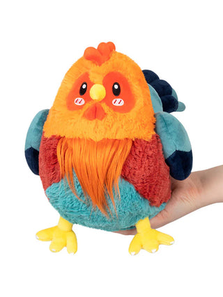 A stuffed animal orange and teal rooster sitting on a hand.