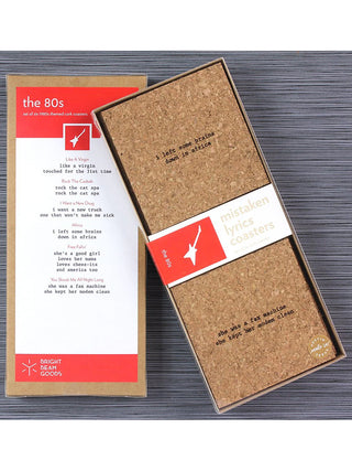 A set of square cork coasters with laser engraved wrong lyrics; the back of the box says "The 80s" and gives a list of songs and the mistaken lyrics.