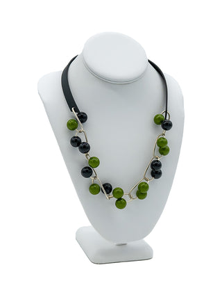 Necklace with black and green beads on silver interlocking chains, held together with a black strap.