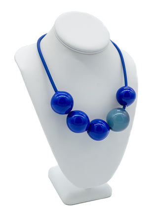 A blue necklace with five blue beads, one lighter than the others.