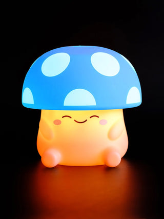 A squishy silicone mushroom night light with a blue and white spotted cap.