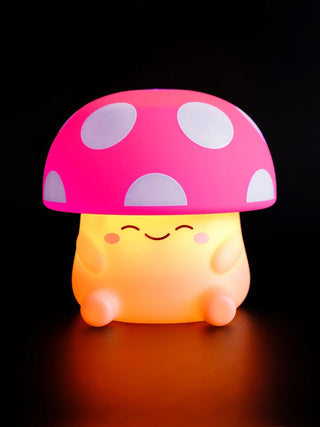A squishy silicone mushroom night light with a pink and white spotted cap.