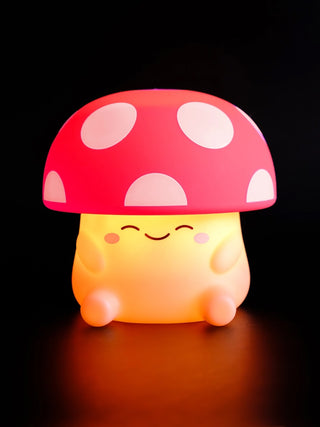 A squishy silicone mushroom night light with a red and white spotted cap.