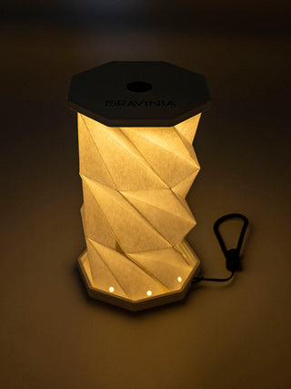 A hexagonal popup lantern, lit, in the dark.