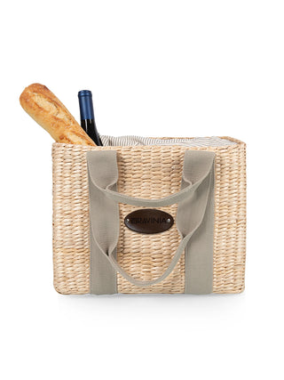 The Ravinia woven picnic basket, holding a bottle of wine and a baguette.