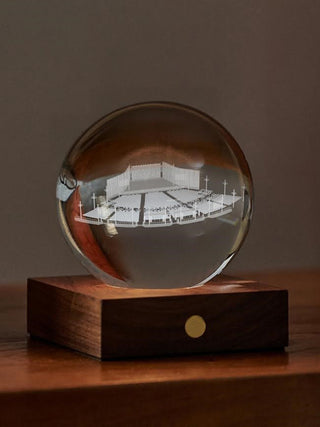 A crystal sphere with an engraved design of the Hunter Pavilion stage sitting atop a wooden base.
