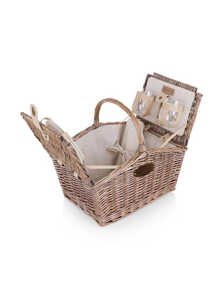 A wicker picnic basket with a leather plate with the Ravinia logo, open to show the canvas interior and storage for included picnicware.