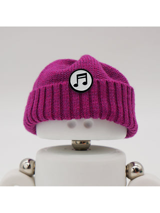 A Marmal figure wearing a plum beanie with a music note pin.