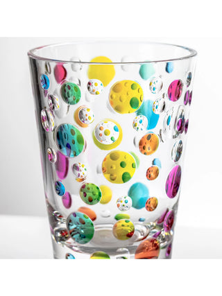 A close-up view of a clear acrylic tumbler with colorful dots.