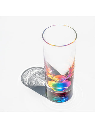 A clear acrylic tumbler with a rainbow teardrop bottom.