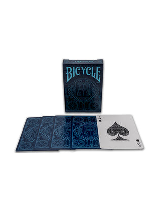 A blue box of Ravinia branded Bicycle playing cards, and four cards from the deck laid out in front of it.