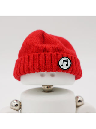 A Marmal figure wearing a red beanie with a music note pin.