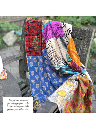 A colorful patchwork blanket made of saris draped over a wooden chair outside, with the words "The pattern shown is for sizing purpose only & does not represent the pattern you will receive."
