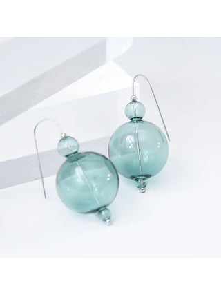 Pair of aqua glass orb earrings on silver wires, on a white background.