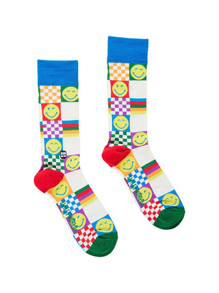A flat pair of socks with smiley faces and colorful rainbow checker designs.
