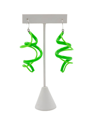 A pair of green spiral earrings on silver wire hooks hanging on a white earring stand.
