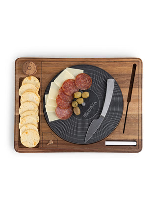 A cheese board that looks like a turntable with crackers, cheese, salami, and olives.