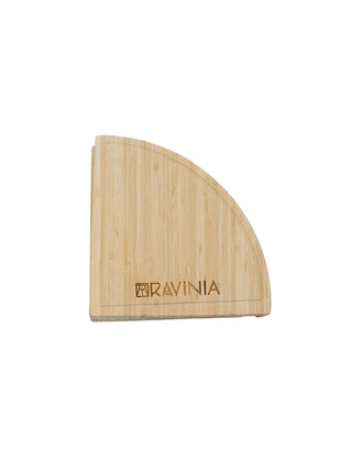 A bamboo cheese board in the shape of a wedge with the Ravinia logo.