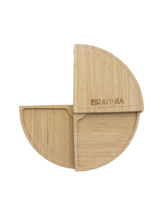 A bamboo cheese board with the Ravinia logo in the shape of 3/4 of a circle.