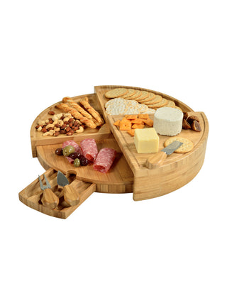 A wooden tiered circular cheese board with a cheese tool drawer, adorned with a charcuterie spread.