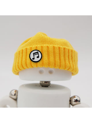 A Marmal figure wearing a yellow beanie with a music note pin.