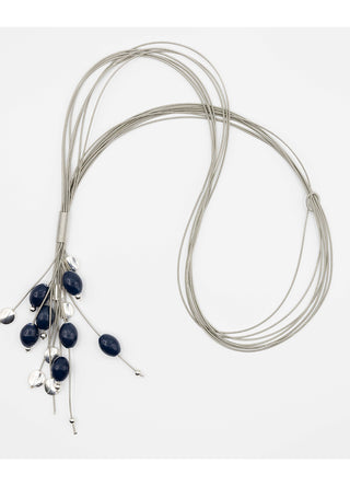 Navy blue porcelain beads dangling from a flowing, piano wire lariat necklace.