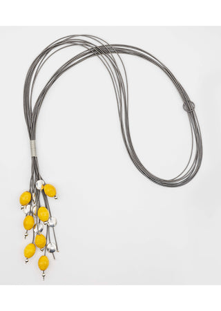 Yellow porcelain beads dangling from a flowing, piano wire lariat necklace.