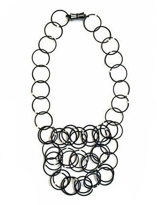 Black loops of piano wire adorned with moonstone form a necklace, with a magnetic clasp.