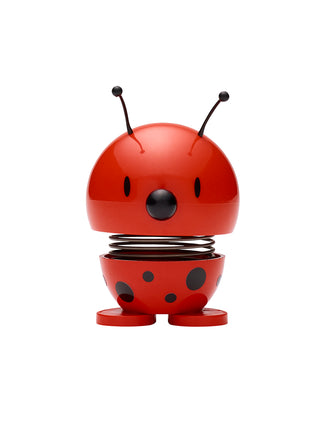 A ladybug-like figure, red with black spots, with a spring in its middle.