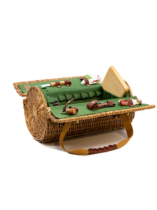 A cylindrical basket, open to reveal a green felt interior with a cutting board, two wine glasses, cheese knife, cork, napkins and other picnic accessories.