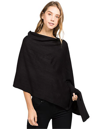 A smiling woman in a black fabric poncho.