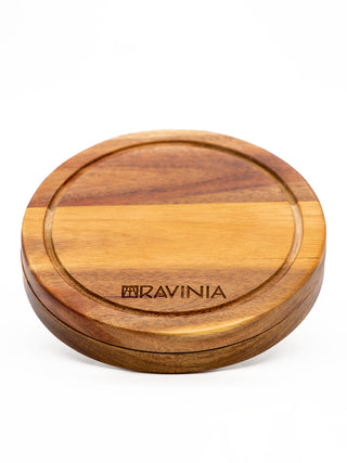 A circular wooden board with the Ravinia logo etched into it near the bottom.