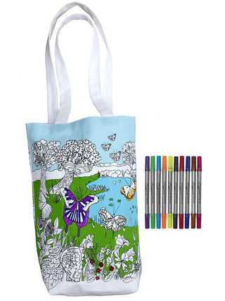 A canvas tote with a nature scene and a purple butterfly on it, with several colored markers adjacent.