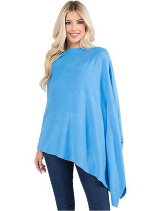 A model in a cornflower blue fabric poncho and jeans.