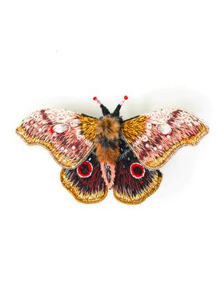 An embroidered brooch in the form of a pink and brown with, with two red spots on its rear wings.