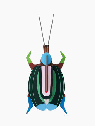 A cardboard beetle with green vertical stripes, green front legs and blue back legs.