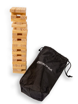 Wooden blocks stacked like a tower next to a black drawstring bag with the word RAVINIA on it.
