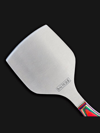 The flat, stainless steel blade of a cheese knife.