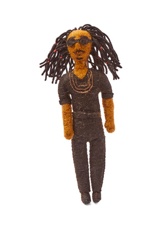 A holiday ornament depicting Stevie Wonder, hanging from a holiday tree branch.