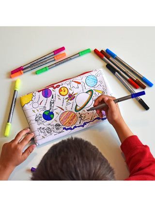 An overhead view of a young boy coloring in the planets side of a space-themed pencil case.