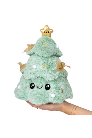 A hand holding up a smiling, plush mini Christmas tree with a smiling star on top.