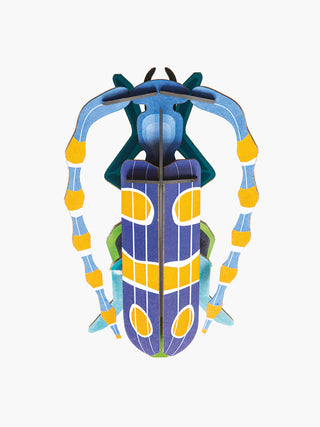 A blue and yellow cardboard beetle with antenna that curve around its body.